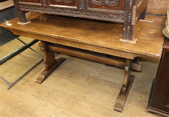 An 18th century style oak trestle dining table on shaped end supports Length 152cm